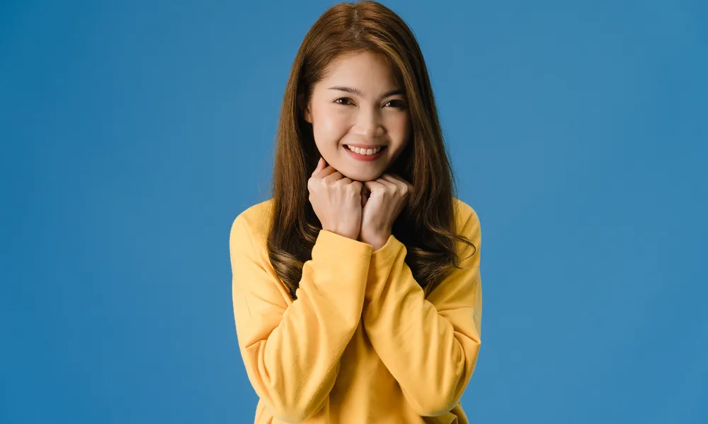 young-asia-lady-with-positive-expression-smile-broadly-dressed-casual-clothing-looking-camera-blue-background-happy-adorable-glad-woman-rejoices-success-facial-expression-concept