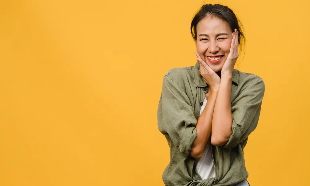 young-asian-lady-with-positive-expression-smile-broadly-dressed-casual-clothing-yellow-wall-happy-adorable-glad-woman-rejoices-success-facial-expression-concept